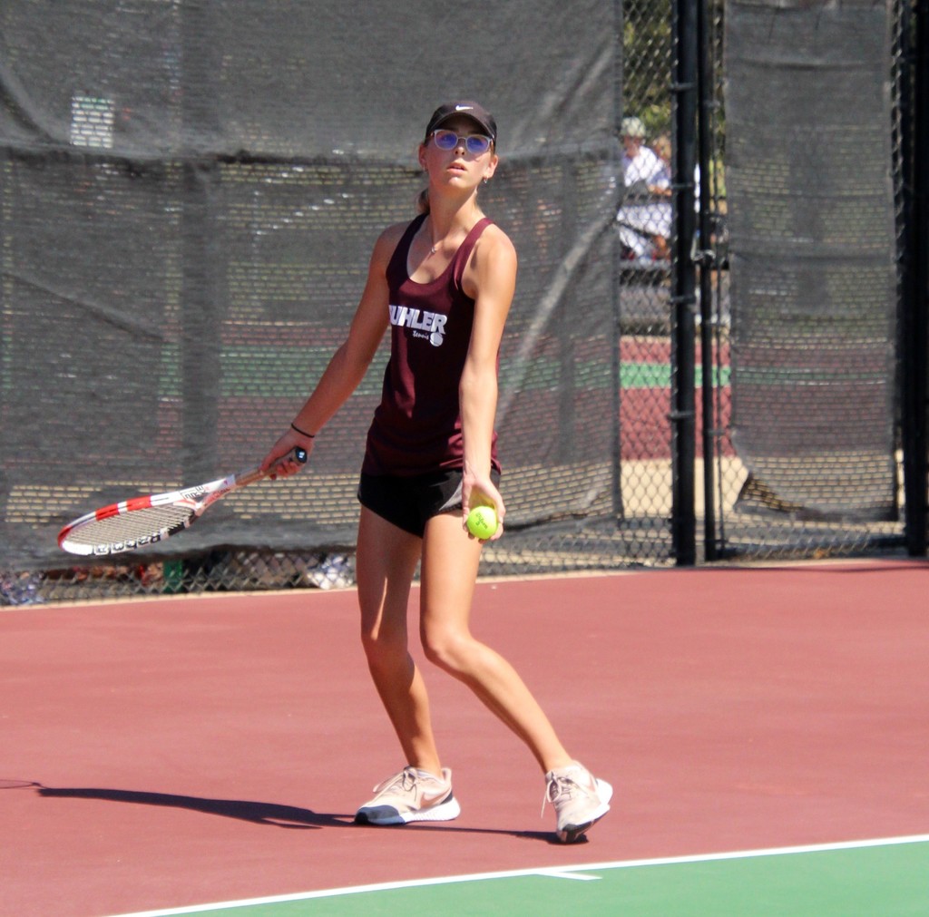 Sienna Douglas serves the ball in a tennis match. 